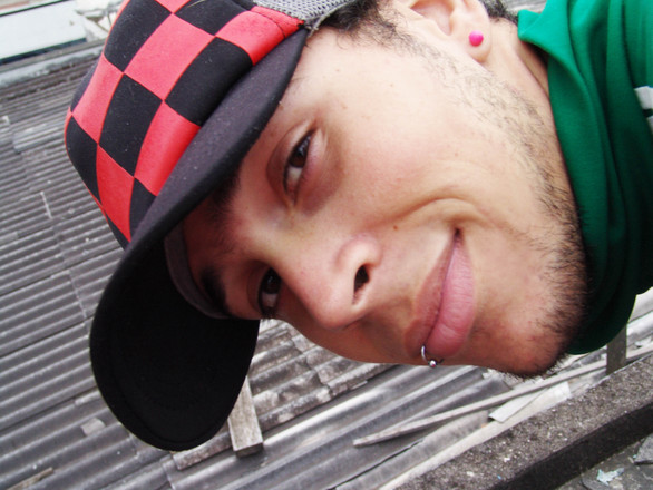 A man with a hat and a lip ring posing for a picture
